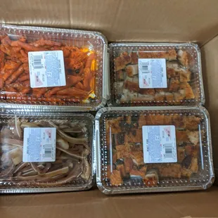 four containers of food in a cardboard box