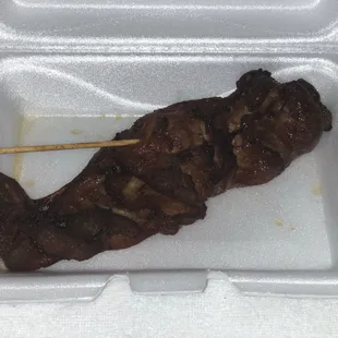 a meat skewer in a styrofoam container
