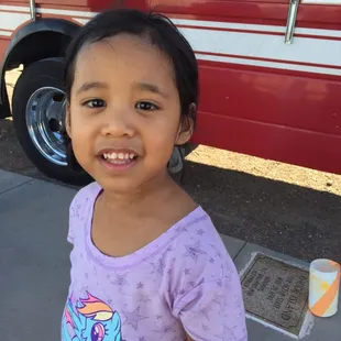 a young girl in front of a food truck