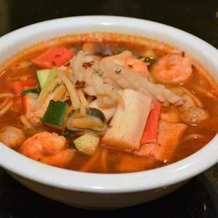 a bowl of soup with shrimp and vegetables