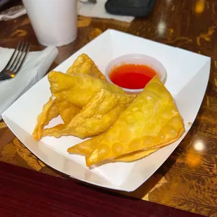 a plate of dumplings and a bowl of sauce