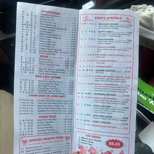 a hand holding a menu for a restaurant