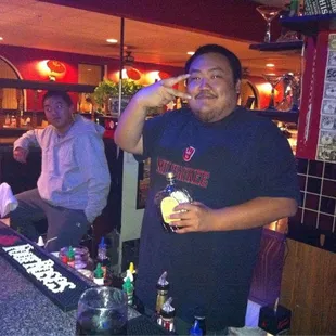 a man drinking a drink at a bar