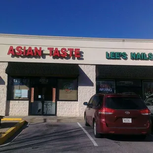 a red car parked in front of a restaurant