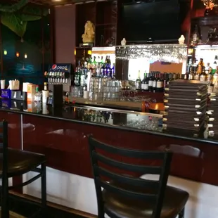 a bar with chairs and a television