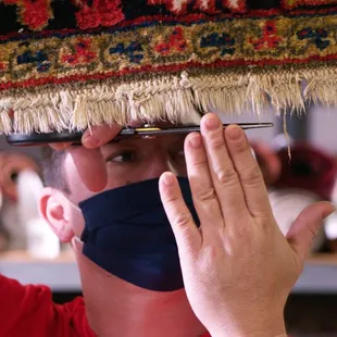 Trimming rug fringe. Each and every rug is carefully inspected and cared for by our professional rug cleaning crew.