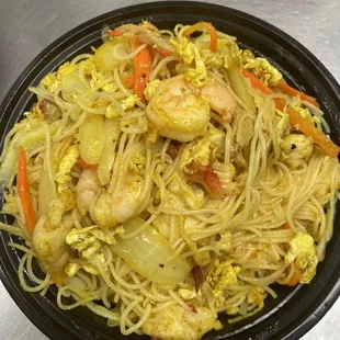 a bowl of noodles with shrimp and vegetables