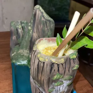 a drink in a ceramic cup with chopsticks in it