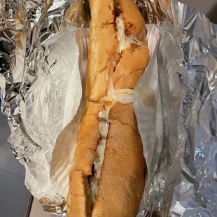 a sandwich wrapped in aluminum foil