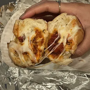 a hand holding a half eaten pizza