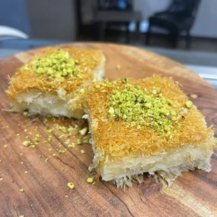 two pieces of dessert on a wooden cutting board
