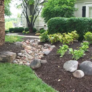 a rock bed in front of a house