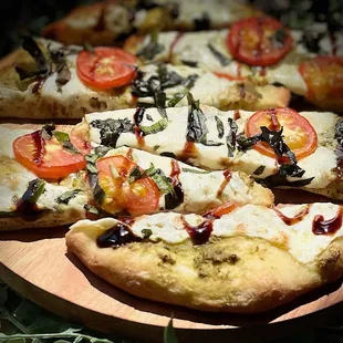 a close up of a pizza with tomatoes and mozzarella