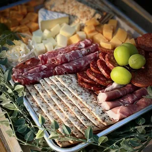 a platter of meat, cheese, and crackers