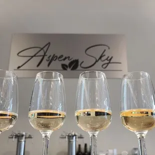 four glasses of wine on a bar