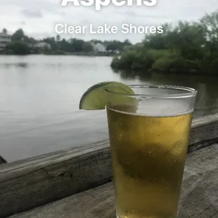 a glass of beer with a lime slice in it