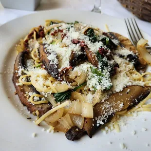 Linguine pasta with mushrooms, onions, and spinach in garlic butter wine sauce