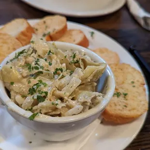 a bowl of pasta and bread on a plate