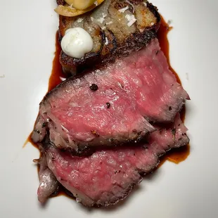 a piece of steak on a white plate