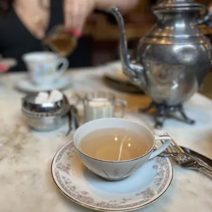 a woman pouring tea into a cup