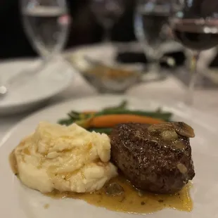 a steak with mashed potatoes and carrots