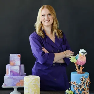 a woman standing in front of a cake