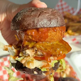 a hand holding up a burger