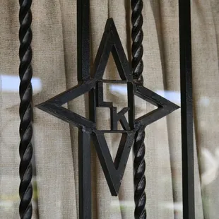 a metal star hanging on a curtain
