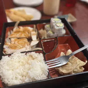 Chicken teriyaki, rice, sushi, yum yum sauce, sweet n sour sauce, and I can&apos;t remember what the other food item
