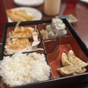 Chicken teriyaki, rice, sushi, yum yum sauce, sweet n sour sauce, and I can&apos;t remember what the other food item