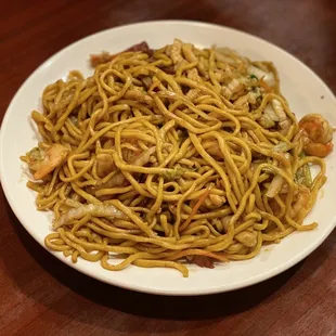 a plate of noodles on a wooden table