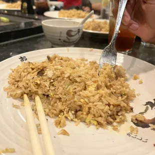 a plate of rice and chopsticks
