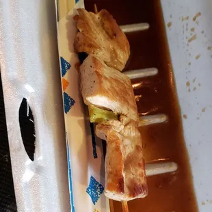 a chicken skewer in a sauce