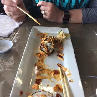 a woman eating sushi with chopsticks