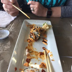 a woman eating sushi with chopsticks
