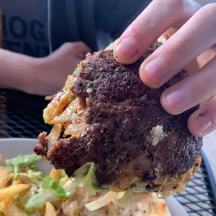 a hand holding a burger