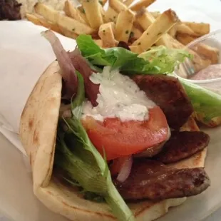 Gyro Pita - Thin-sliced beef wrapped in warm pita, topped with spring greens, tomato, onion, and tzatzíki. Fresh cut fries.