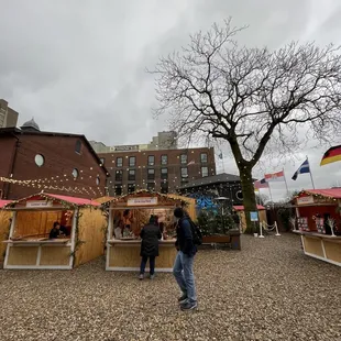 a man and a woman standing in front of a christmas market