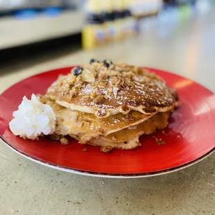 a stack of pancakes on a red plate