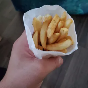 a person holding a basket of french fries
