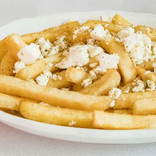 a plate of french fries with feta cheese