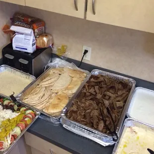 Amazing catering spread with salad and gyros.