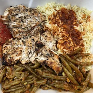 Chicken breast dinner with rice and green beans.