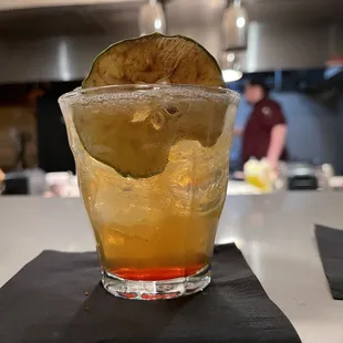 a cocktail with a lime slice in it
