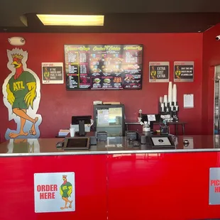 a red counter with a menu on the wall