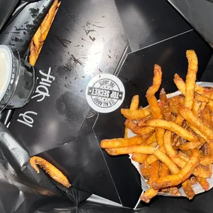 fries and a drink in a black bag