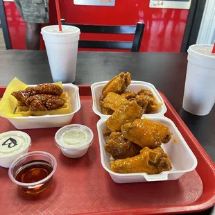 a tray of chicken wings and dipping sauces
