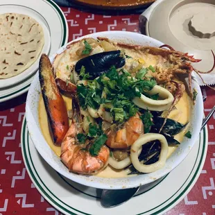 Seafood soup with a side of tortilla (on the left, included with dish).