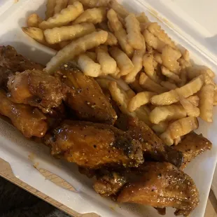 chicken wings and fries in a styrofoam container