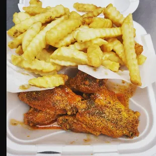 a tray of chicken wings and french fries